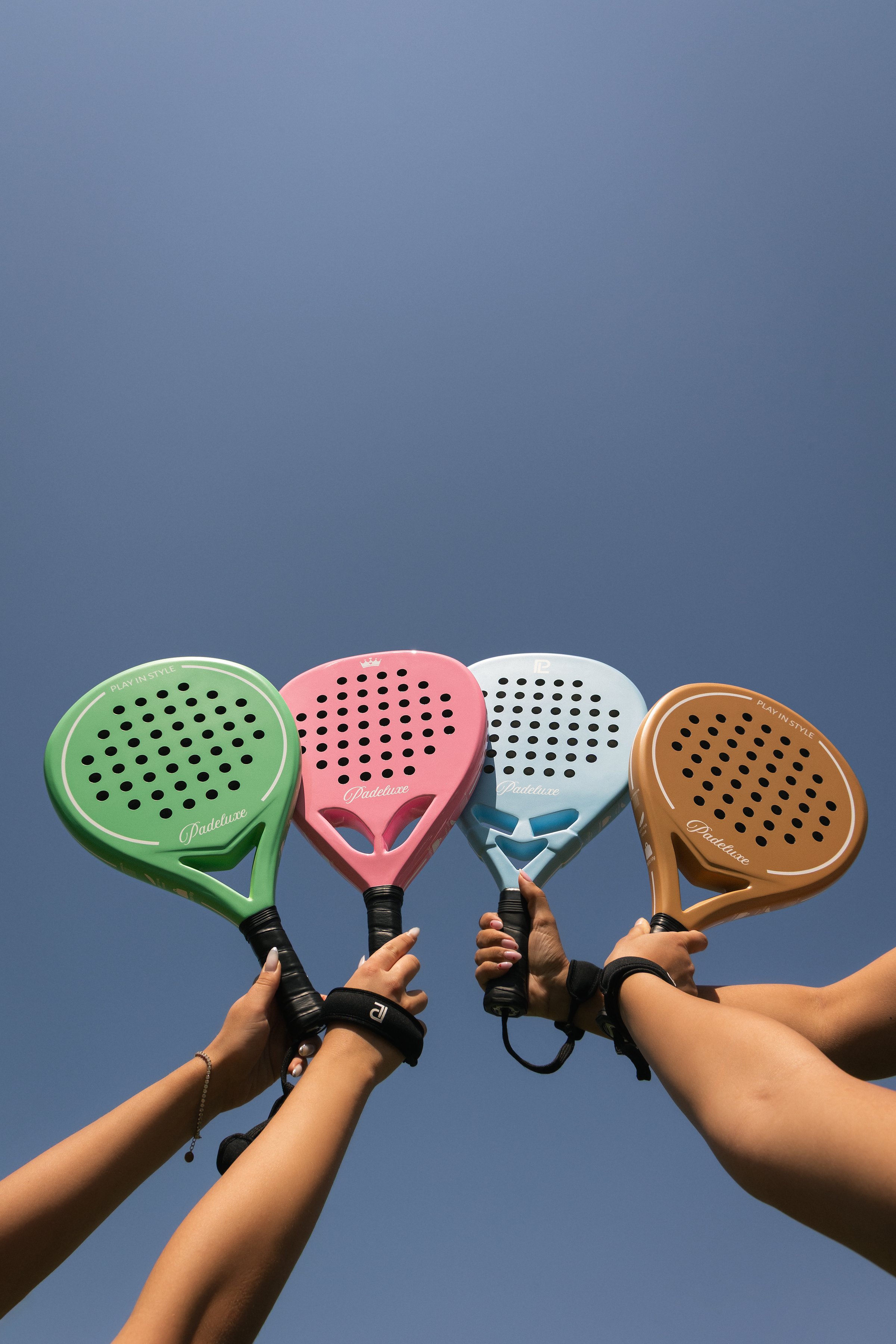 Padeluxe padel rackets against a clear blue sky